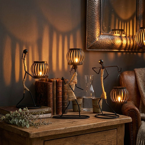 Handcrafted tribal lady metal candle holder with jute wrapping and matte black finish, holding a flickering tea light candle on a rustic wooden table
