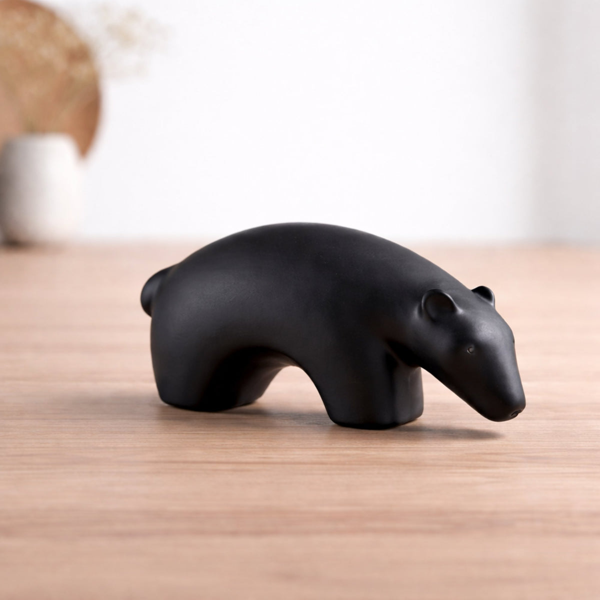 Black bear-shaped object on a wooden surfac