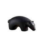 Minimalist matte black ceramic bear sculpture set on wooden surface 