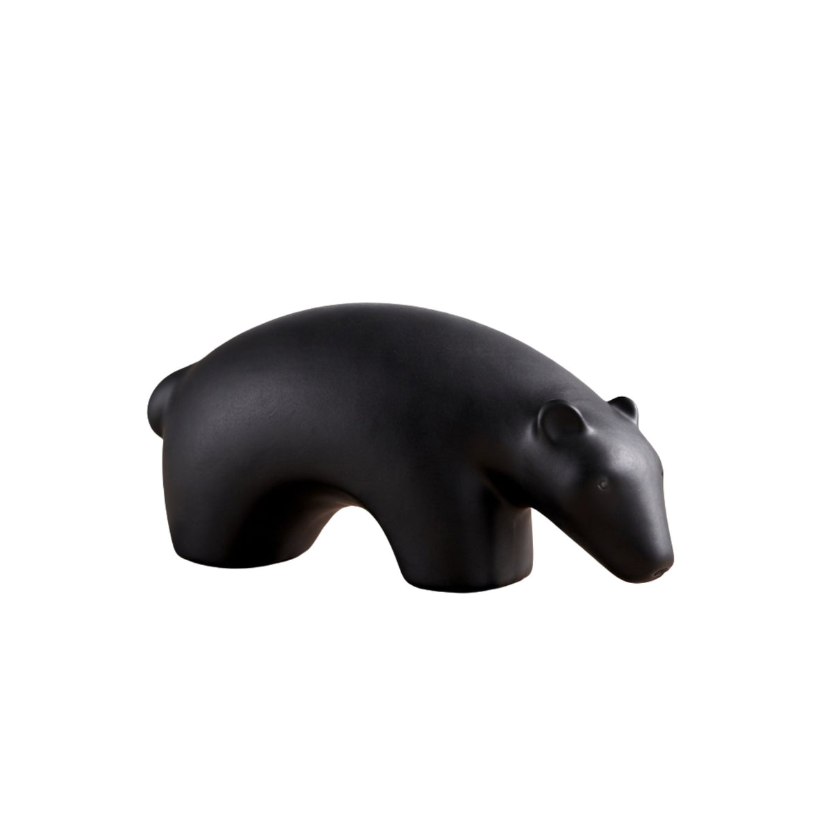Minimalist matte black ceramic bear sculpture set on wooden surface 