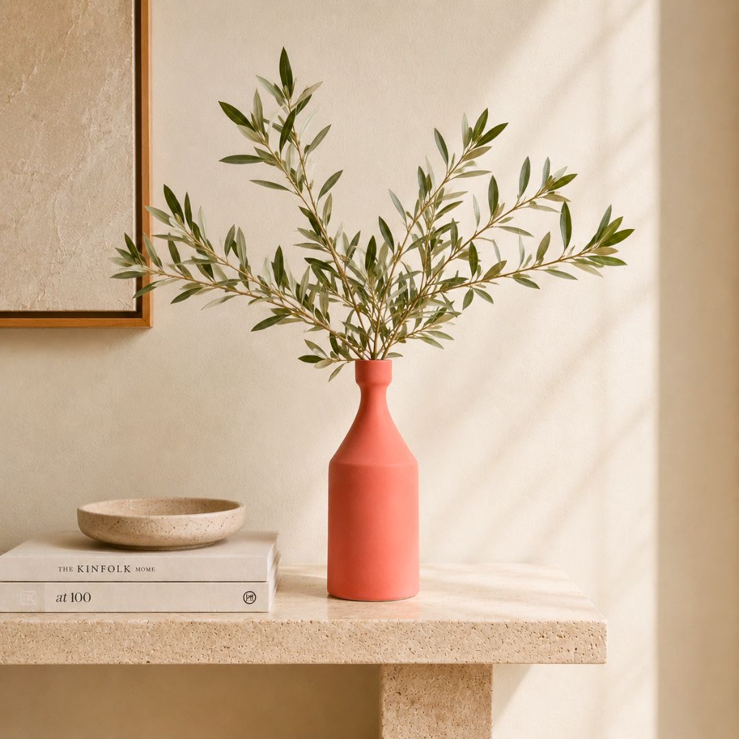 Luxury ceramic bottle-shaped vase with matte finish styled on a beige travertine console table in a modern Scandinavian-inspired interior with olive branches and minimalist décor.