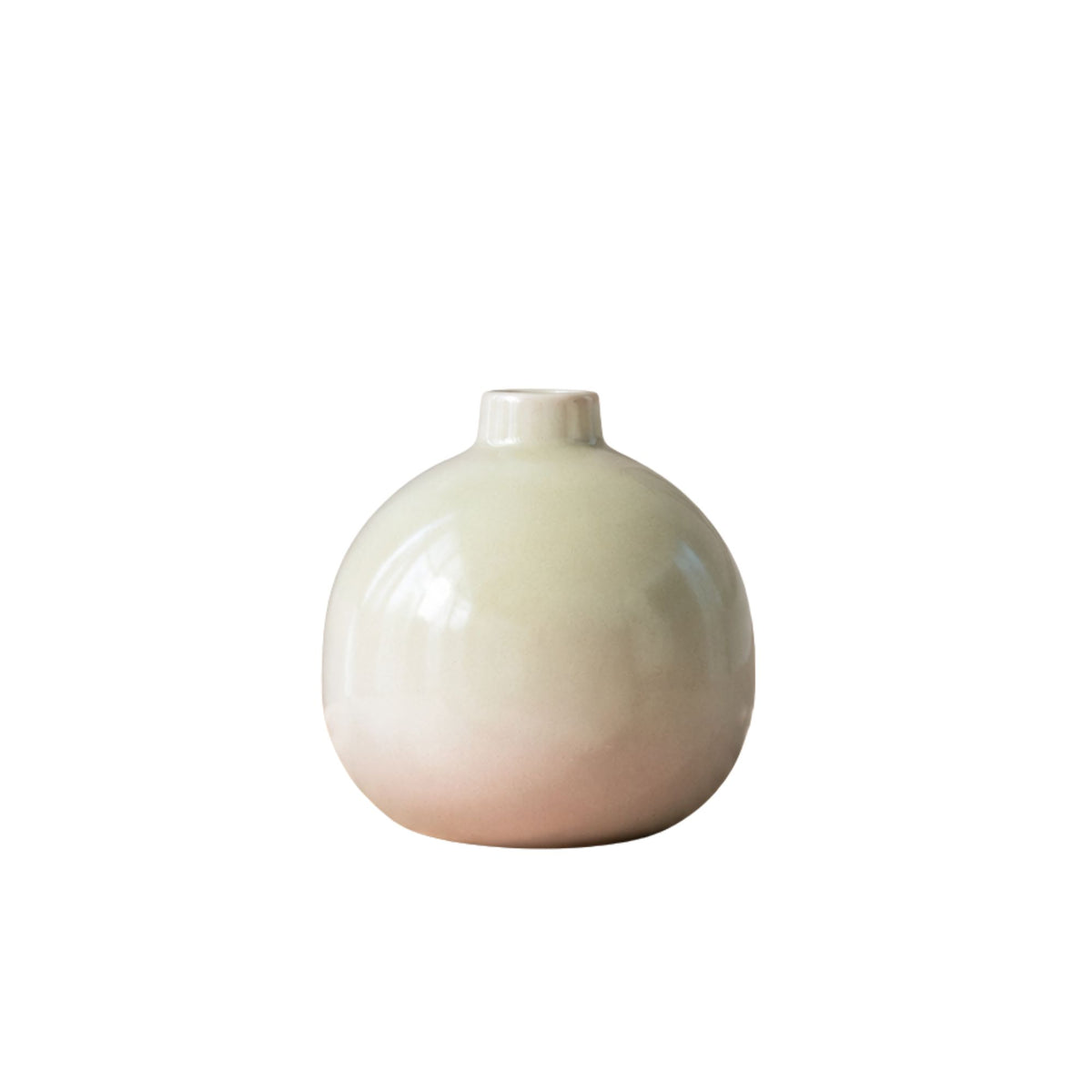 Luxury round ceramic flower vase in minimalist modern design held in hand against vibrant pink background for premium home décor and office styling.