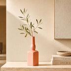 Luxury ceramic bottle-shaped vase with matte finish styled on a beige travertine console table in a modern Scandinavian-inspired interior with olive branches and minimalist décor.