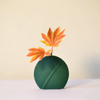 Elegant leaf-shaped ceramic decorative flower vase set with matte finish styled in a modern luxury Indian living room interior with fresh floral arrangement