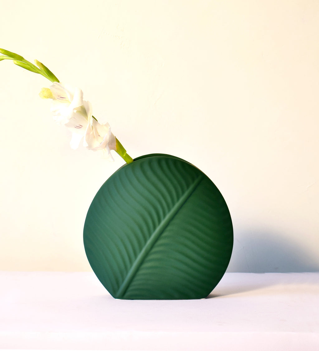 Elegant leaf-shaped ceramic decorative flower vase set with matte finish styled in a modern luxury Indian living room interior with fresh floral arrangement