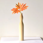 Luxury slim Nordic ceramic flower vase with matte grey finish and orange artificial maple leaves on white table for modern home décor interiors.