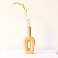 Modern hollow linear ceramic flower vase styled with pampas grass in a minimalist Indian living room interior décor setup
