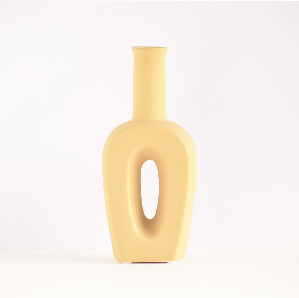 Modern hollow linear ceramic flower vase styled with pampas grass in a minimalist Indian living room interior décor setup