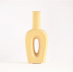 Modern hollow linear ceramic flower vase styled with pampas grass in a minimalist Indian living room interior décor setup