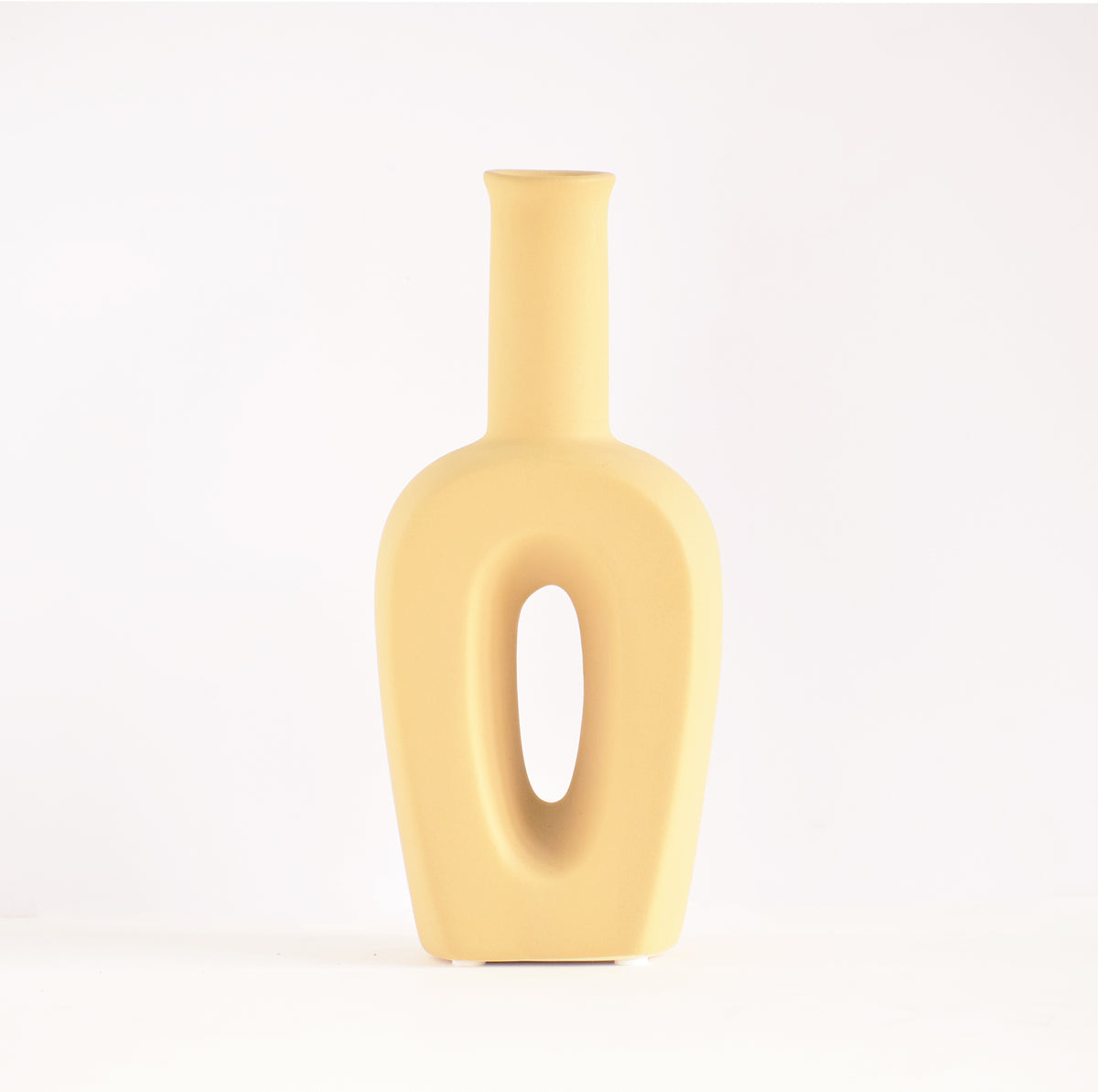 Modern hollow linear ceramic flower vase styled with pampas grass in a minimalist Indian living room interior décor setup