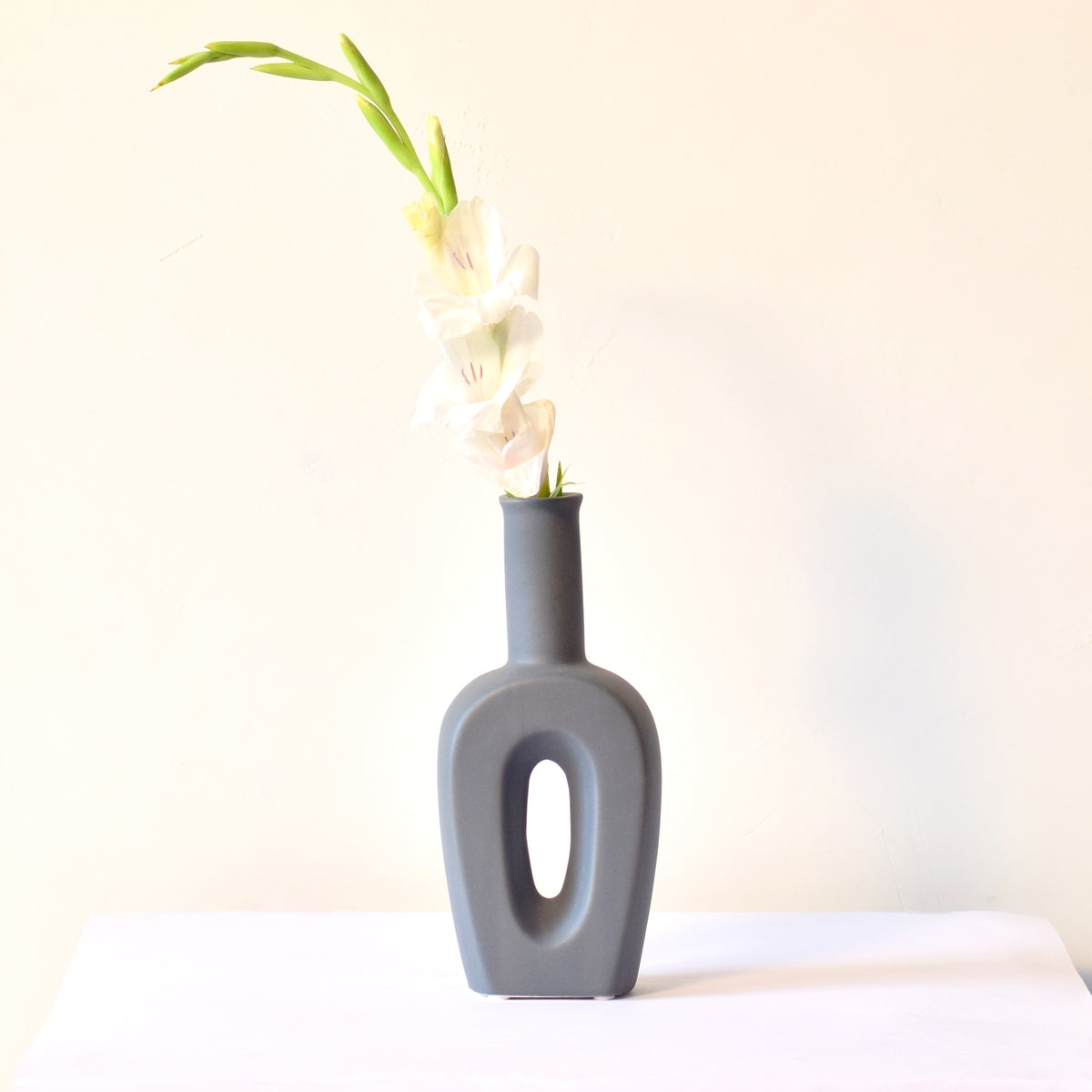 Modern hollow linear ceramic flower vase styled with pampas grass in a minimalist Indian living room interior décor setup
