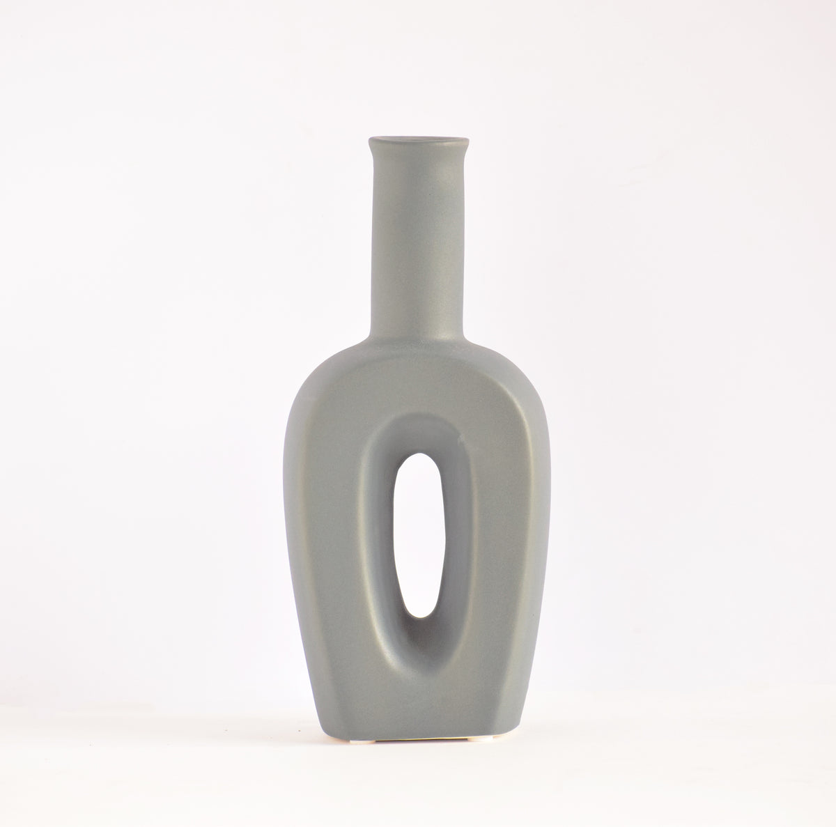 Modern hollow linear ceramic flower vase styled with pampas grass in a minimalist Indian living room interior décor setup