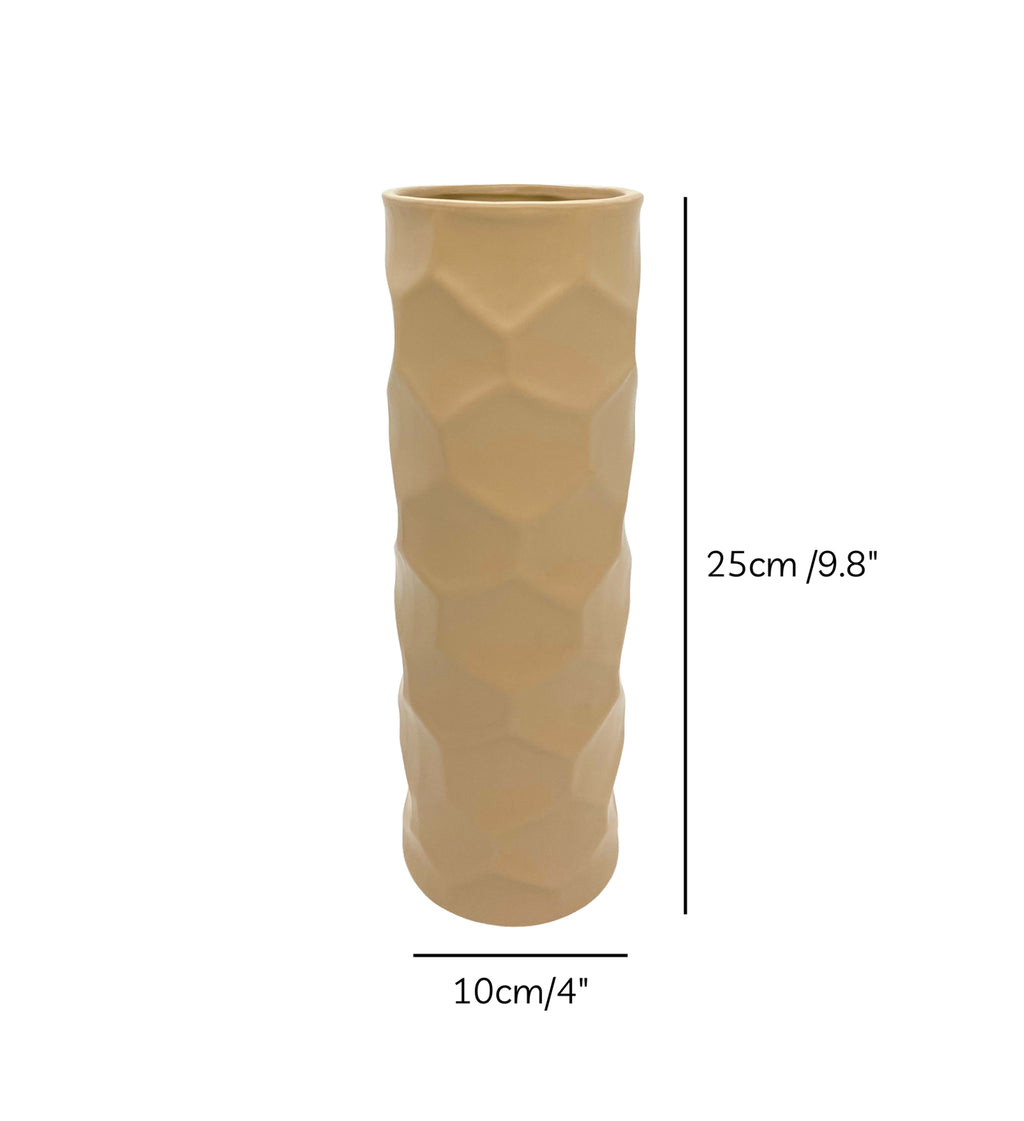 Luxury beige honeycomb ceramic flower vase with white flowers styled on a wooden console table in a modern minimalist living room interior.