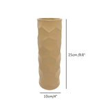 Luxury beige honeycomb ceramic flower vase with white flowers styled on a wooden console table in a modern minimalist living room interior.