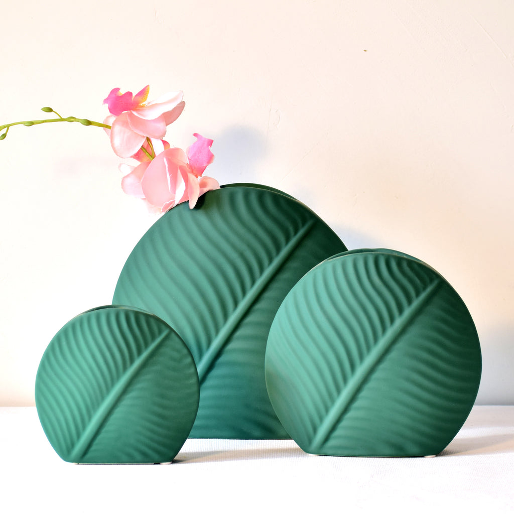 Elegant leaf-shaped ceramic decorative flower vase set with matte finish styled in a modern luxury Indian living room interior with fresh floral arrangement