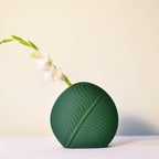 Elegant leaf-shaped ceramic decorative flower vase set with matte finish styled in a modern luxury Indian living room interior with fresh floral arrangement