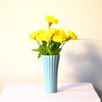 Sky blue ribbed ceramic flower vase with yellow flowers for modern luxury home décor and contemporary interior styling in India