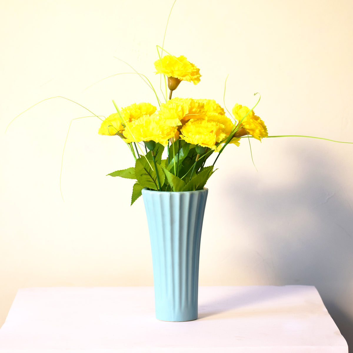 Sky blue ribbed ceramic flower vase with yellow flowers for modern luxury home décor and contemporary interior styling in India