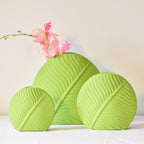 Mint green leaf ceramic flower vase styled with fresh blooms in a modern luxury living room featuring elegant contemporary décor.