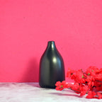 Nordic Linear VaseMinimal black ceramic flower vase with red floral arrangement on vibrant pink background