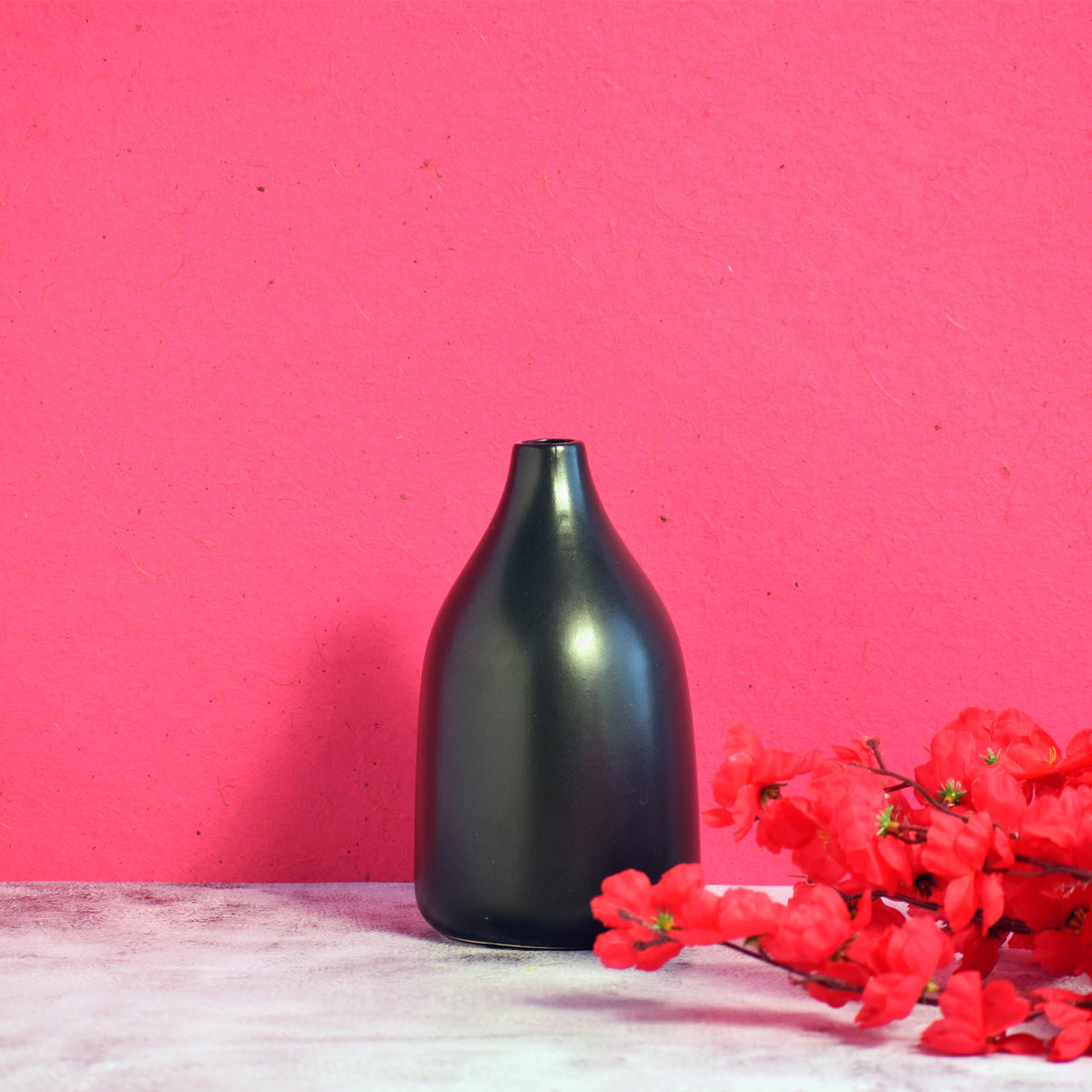 Nordic Linear VaseMinimal black ceramic flower vase with red floral arrangement on vibrant pink background