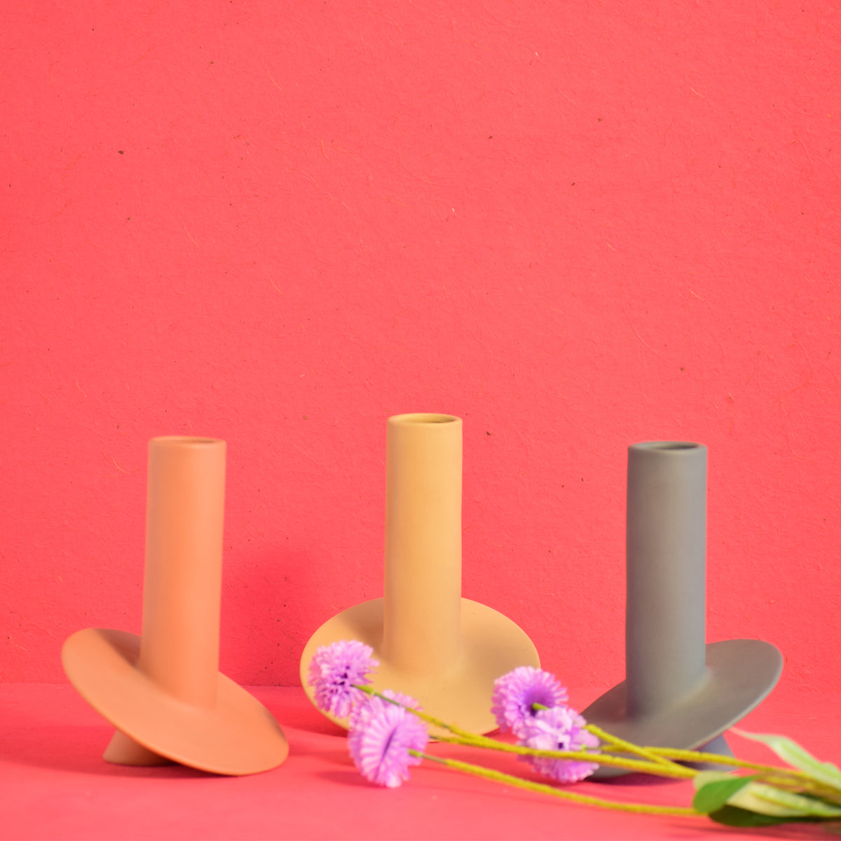 Handmade orbital ceramic flower vase with sculptural modern design styled with flowers in a luxury contemporary living room.