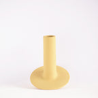 Handmade orbital ceramic flower vase with sculptural modern design styled with flowers in a luxury contemporary living room.