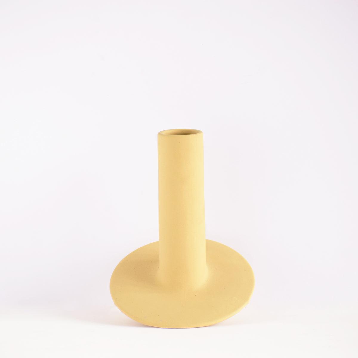 Handmade orbital ceramic flower vase with sculptural modern design styled with flowers in a luxury contemporary living room.