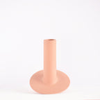 Handmade orbital ceramic flower vase with sculptural modern design styled with flowers in a luxury contemporary living room.