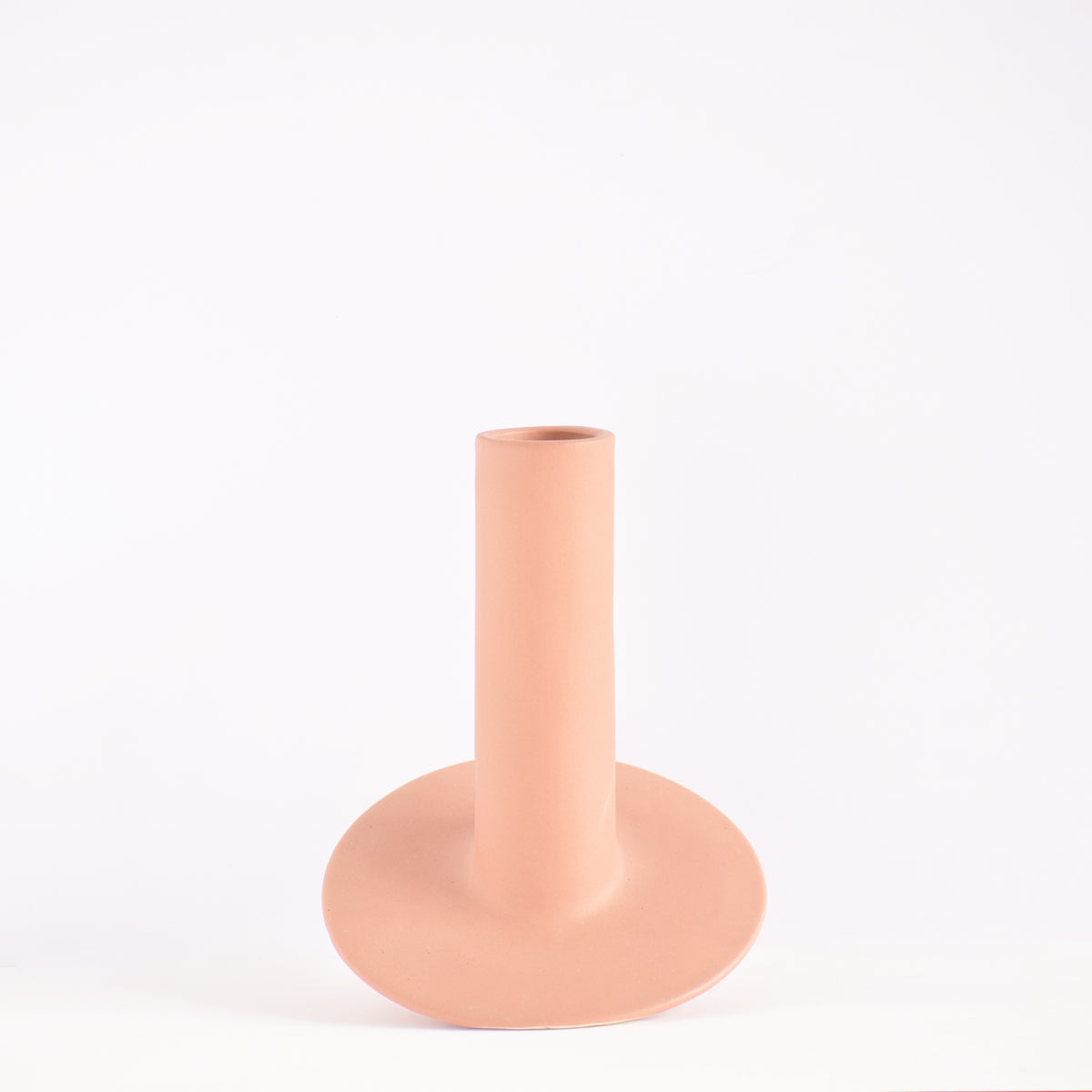 Handmade orbital ceramic flower vase with sculptural modern design styled with flowers in a luxury contemporary living room.