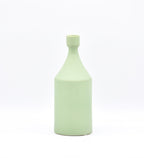 Luxury ceramic bottle-shaped vase with matte finish styled on a beige travertine console table in a modern Scandinavian-inspired interior with olive branches and minimalist décor.