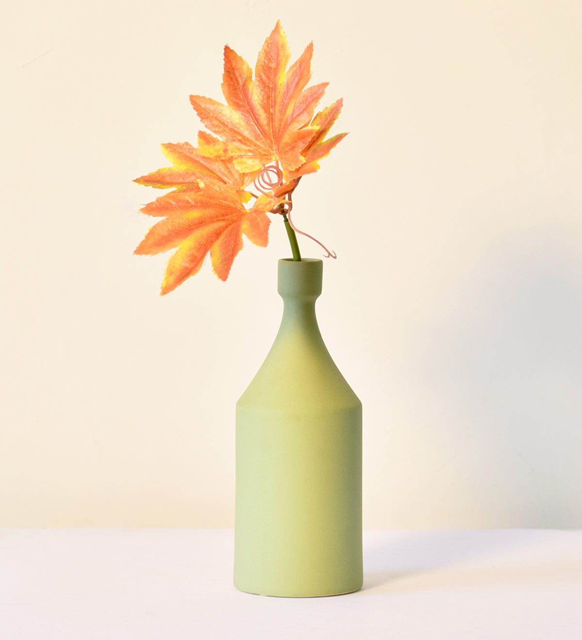 Round Bottle VaseLuxury ceramic bottle-shaped vase with matte finish styled on a beige travertine console table in a modern Scandinavian-inspired interior with olive branches and minimalist décor.