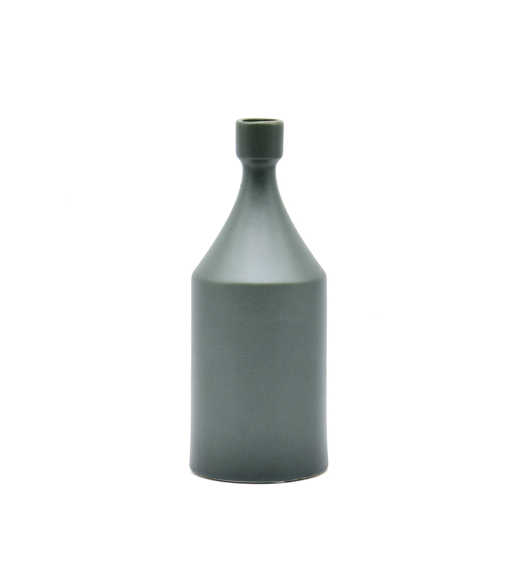 Luxury ceramic bottle-shaped vase with matte finish styled on a beige travertine console table in a modern Scandinavian-inspired interior with olive branches and minimalist décor.