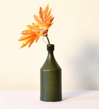 Luxury ceramic bottle-shaped vase with matte finish styled on a beige travertine console table in a modern Scandinavian-inspired interior with olive branches and minimalist décor.