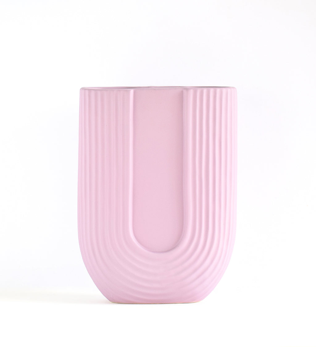 Luxury U-shaped ceramic flower vase with sculptural modern design styled in an elegant contemporary living room interior.