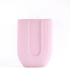 Luxury U-shaped ceramic flower vase with sculptural modern design styled in an elegant contemporary living room interior.