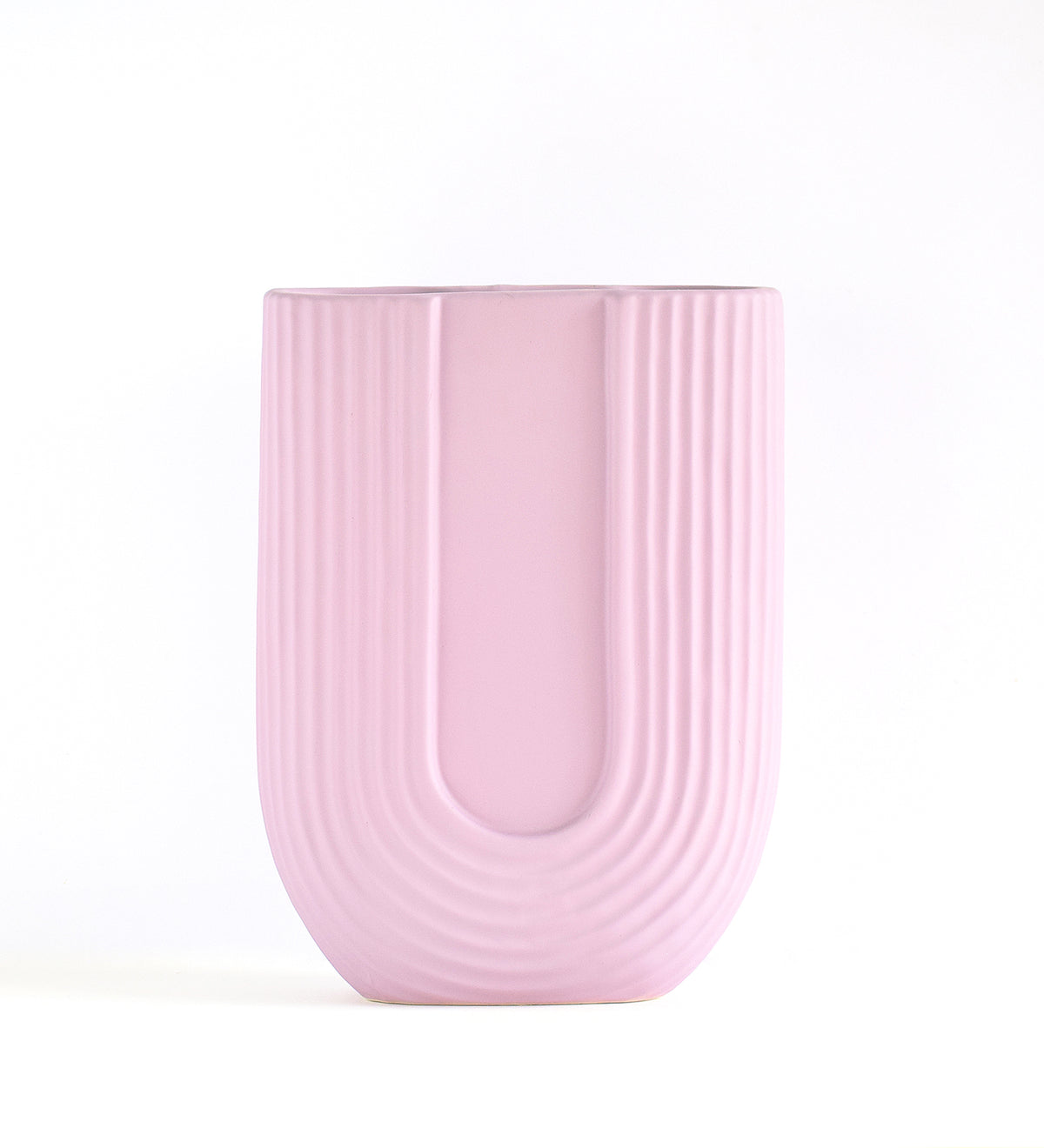 Luxury U-shaped ceramic flower vase with sculptural modern design styled in an elegant contemporary living room interior.