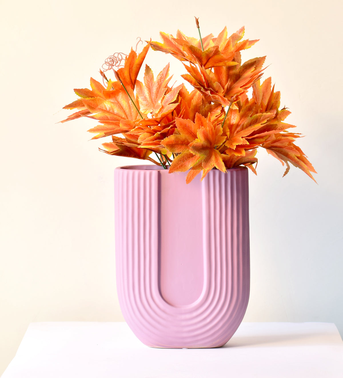 Luxury U-shaped ceramic flower vase with sculptural modern design styled in an elegant contemporary living room interior.