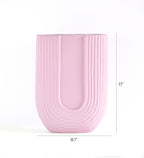 Luxury U-shaped ceramic flower vase with sculptural modern design styled in an elegant contemporary living room interior.