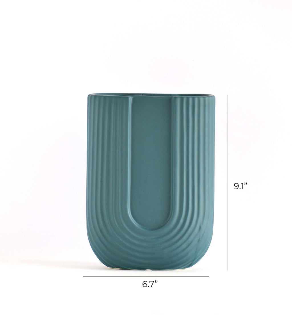 Modern U-shaped ribbed ceramic decorative flower vase styled with dried pampas grass in a luxury minimalist Indian living room interior