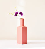 Luxury ceramic bottle-shaped vase with matte finish styled on a beige travertine console table in a modern Scandinavian-inspired interior with olive branches and minimalist décor.