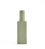 Luxury ceramic bottle-shaped vase with matte finish styled on a beige travertine console table in a modern Scandinavian-inspired interior with olive branches and minimalist décor.