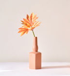 Luxury ceramic bottle-shaped vase with matte finish styled on a beige travertine console table in a modern Scandinavian-inspired interior with olive branches and minimalist décor.