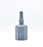 Luxury ceramic bottle-shaped vase with matte finish styled on a beige travertine console table in a modern Scandinavian-inspired interior with olive branches and minimalist décor.