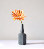 Luxury ceramic bottle-shaped vase with matte finish styled on a beige travertine console table in a modern Scandinavian-inspired interior with olive branches and minimalist décor.