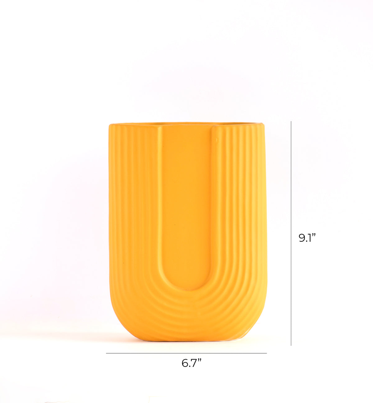 Luxury U-shaped ceramic flower vase with sculptural modern design styled in an elegant contemporary living room interior.