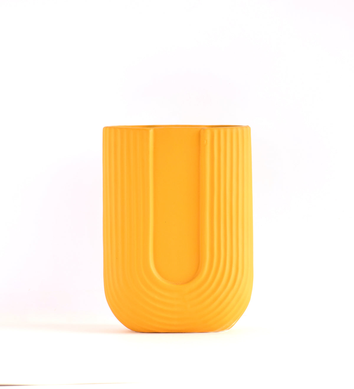 Luxury U-shaped ceramic flower vase with sculptural modern design styled in an elegant contemporary living room interior.