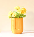 Luxury U-shaped ceramic flower vase with sculptural modern design styled in an elegant contemporary living room interior.